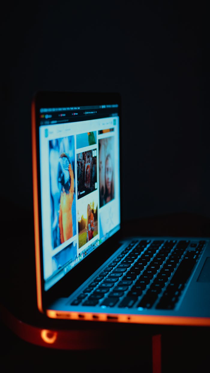 A laptop screen showing pictures in a dimly lit room, highlighting digital era browsing.